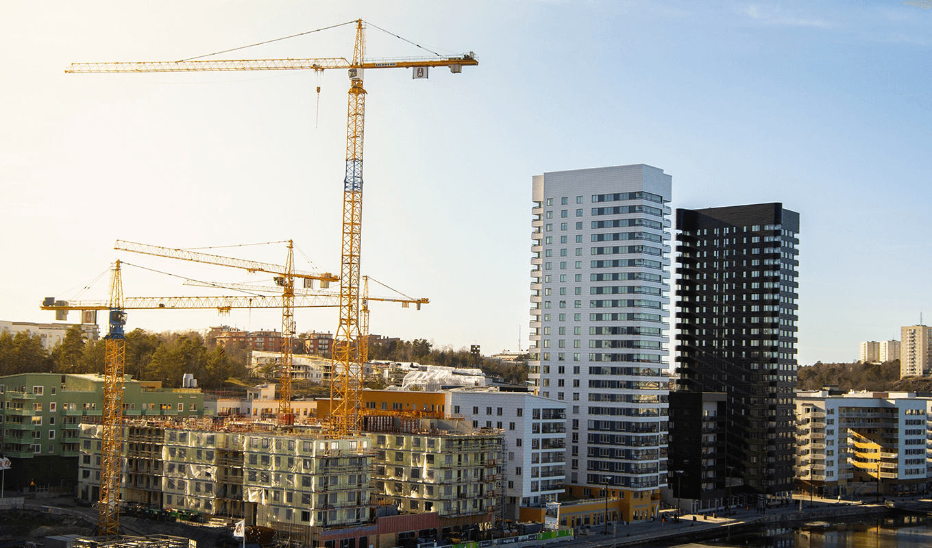 En svensk stad med höghus och lyftkranar.